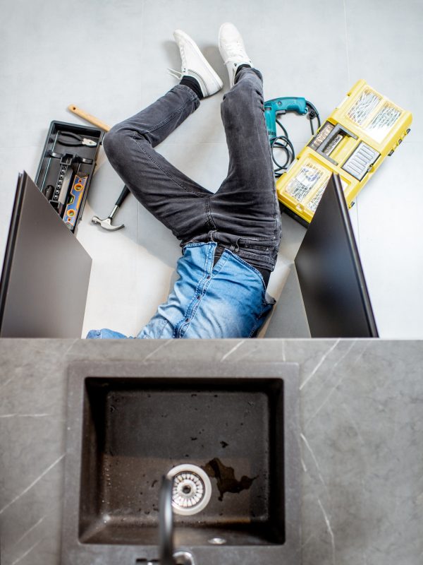 Man repairing kitchen plumbing Man repairing kitchen plumbing