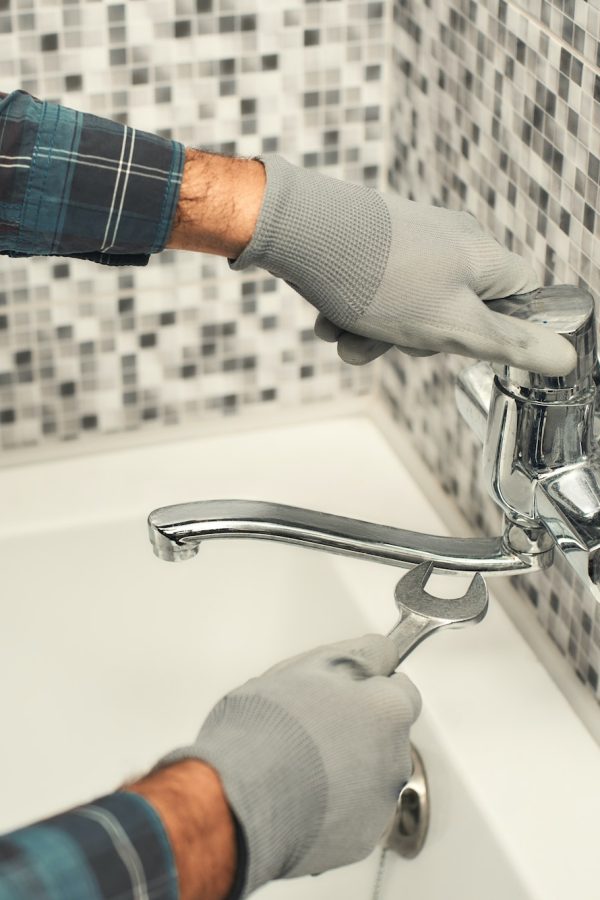 Plumber repairing a tap in the bathroom