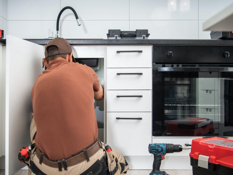 Plumbing Technician Finishing Kitchen Sink Pipeline Installation